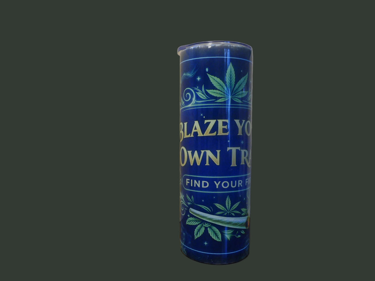 Blaze Your Own Trail 20 oz skinny tumbler with gold script, cannabis leaves and swirling botanicals on a deep midnight blue background